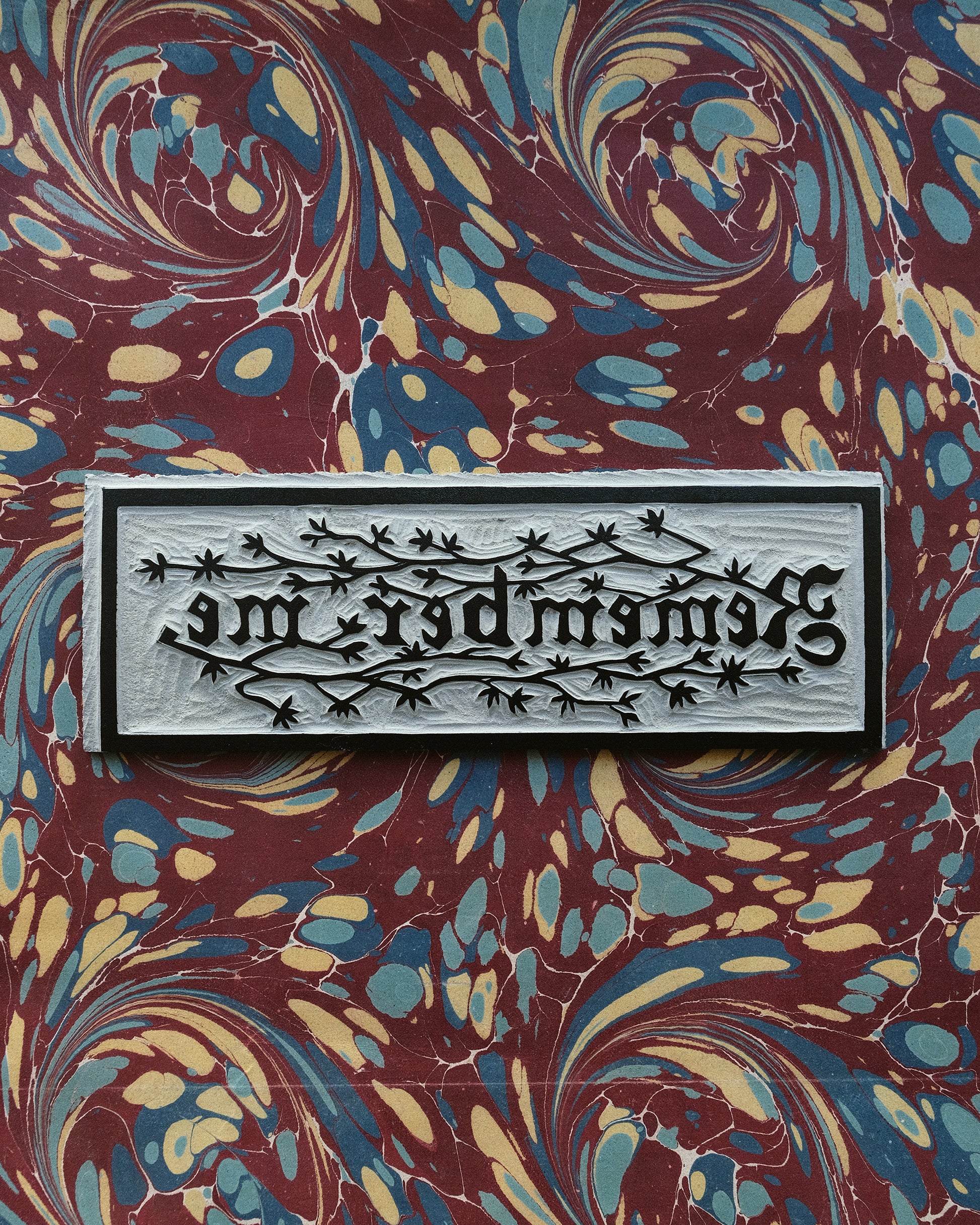 Decorative lino block bookmark on marbled pattern background